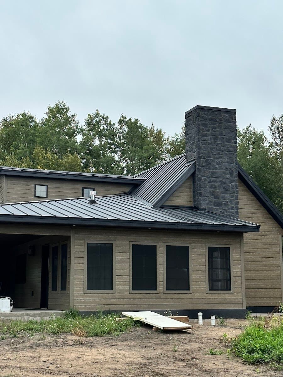 Vita Roofing project — standing-seam metal roof with stone chimney in the Fargo-Moorhead area